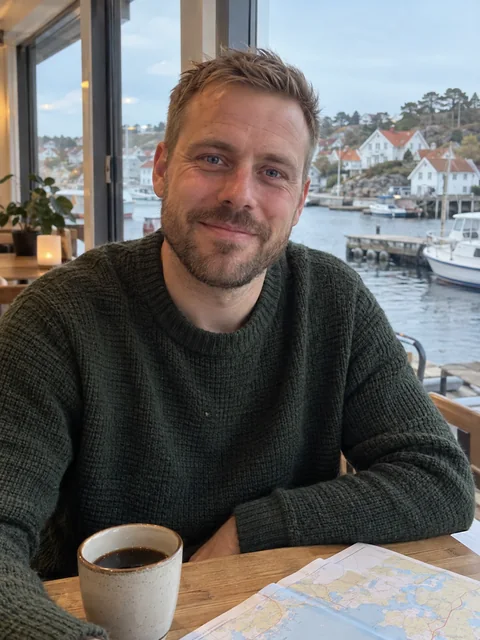 Emil Mats Larsen Olsen med kart og kaffe på en kafé ved havna